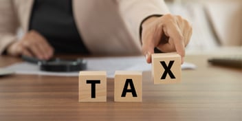 wooden blocks that spell out the word tax