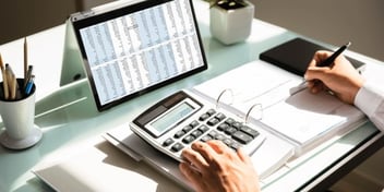 Person using calculator at their desk