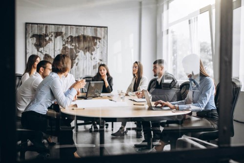 corporate meeting with people sitting around a table talking