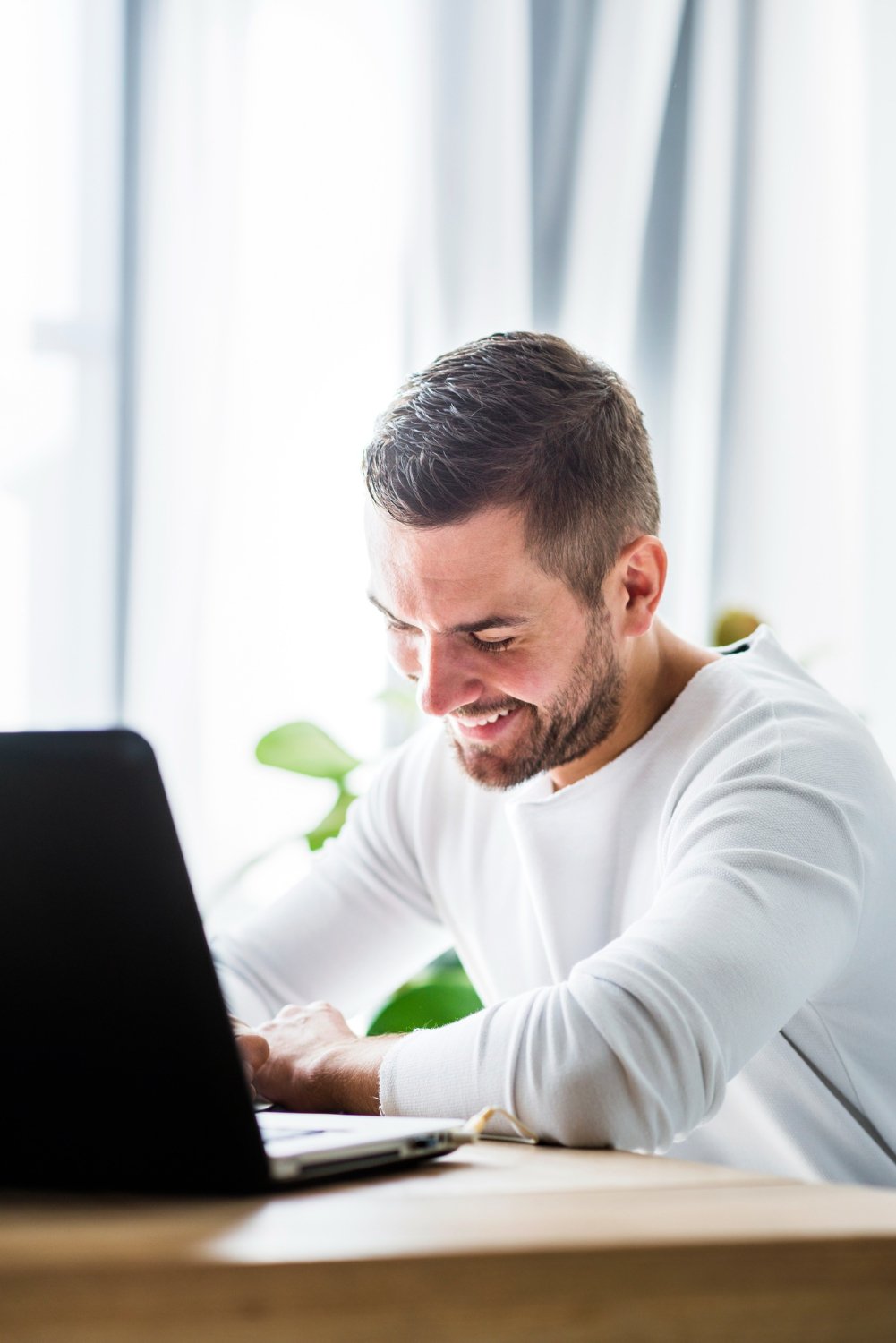 man at a computer typing and smiling