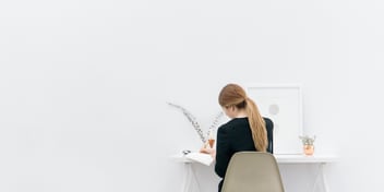woman sitting at desk making notes