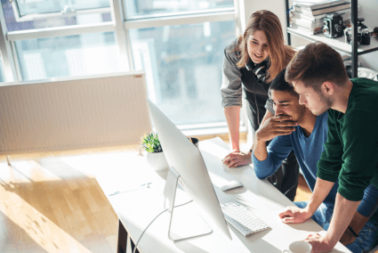 three people working around a computer together